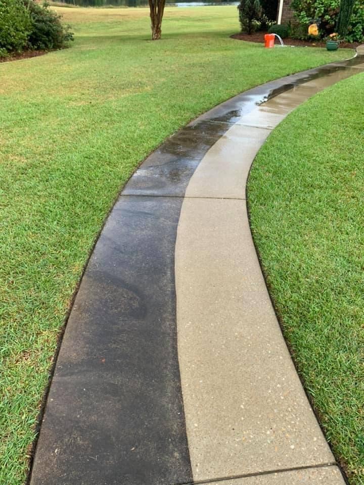 Professional pressure washing equipment cleaning concrete driveway